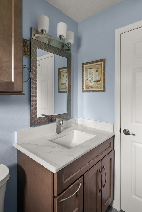blue guest bathroom with a wood vanity 