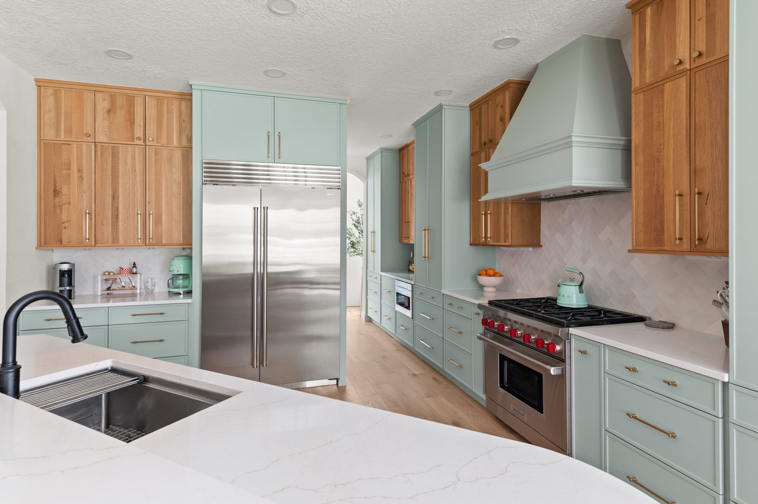 Windermer, FL soft blue-green cabinetry with natural wood, fridge and plenty of cabinets